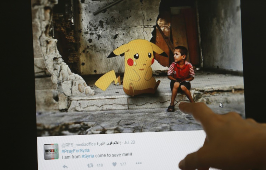 phénomène mondial 1008x646_un_journaliste_montre_le_montage_d_un_artiste_syrien_alliant_guerre_en_syrie_et_pokmon_go__beyrouth_le_22_juillet_2016