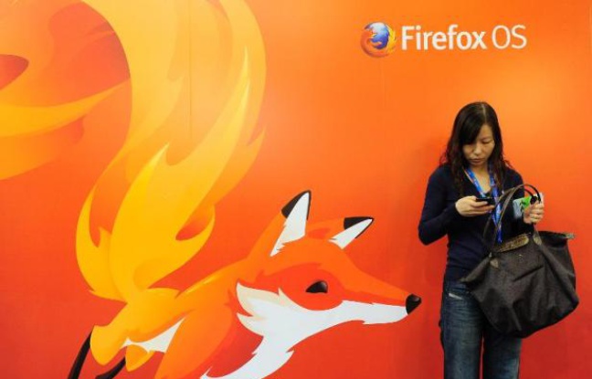 Une femme regarde son téléphone devant un poster de Mozilla Firefox à Barcelone au Congrès mondial de la téléphonie, le 27 février 2013 Une femme regarde son téléphone devant un poster de Mozilla Firefox à Barcelone au Congrès mondial de la téléphonie, le 27 février 2013