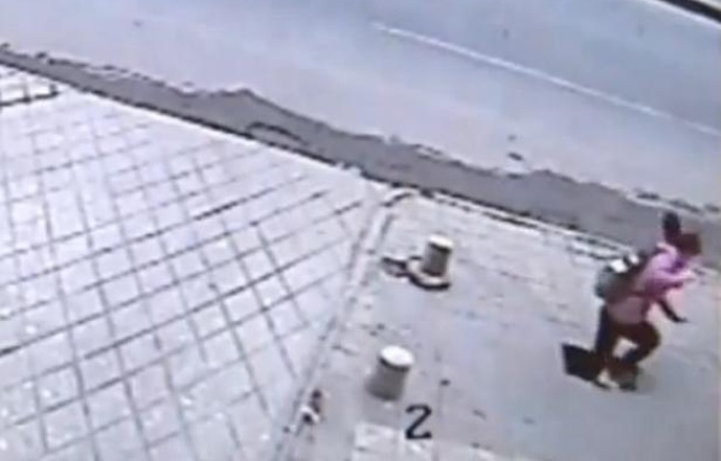 Capture d'écran d'une vidéo montrant une jeune fille chuter de 6 mètres à travers le trottoir, en Chine. Capture d'écran d'une vidéo montrant une jeune fille chuter de 6 mètres à travers le trottoir, en Chine.