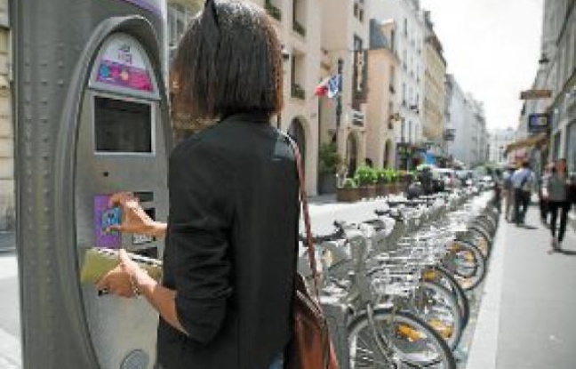 Les usagers déposent leur carte d'abonné contre la borne et retirent un Vélib'. Les usagers déposent leur carte d'abonné contre la borne et retirent un Vélib'.