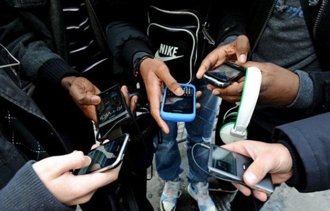 Des jeunes utilisent leur téléphone portable Des jeunes utilisent leur téléphone portable