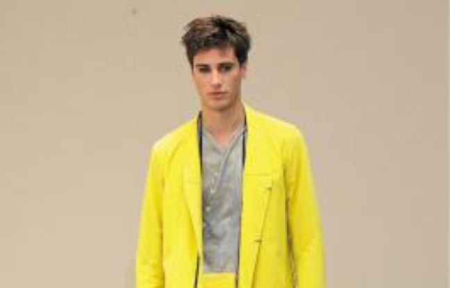 De gauche à droite :Veste à boutons en toile de coton jaune acide, chemise en popeline de coton et soie grise, pantalon droit en maille de coton kaki. Gustavo Lins. Imperméable en toile de coton jaune acide, tee-shirt en jersey de coton imprimé « dripping » sable d'or, pantalon droit en toile de coton sable. Collier-pochette en cuir surpiqué jaune acide. De gauche à droite :Veste à boutons en toile de coton jaune acide, chemise en popeline de coton et soie grise, pantalon droit en maille de coton kaki. Gustavo Lins. Imperméable en toile de coton jaune acide, tee-shirt en jersey de coton imprimé « dripping » sable d'or, pantalon droit en toile de coton sable. Collier-pochette en cuir surpiqué jaune acide.