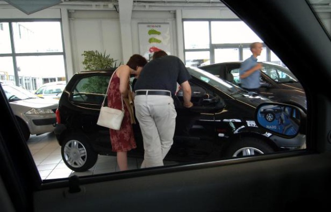 Un couple regarde l'intérieur d'une automobile chez un concessionnaire Renault. Un couple regarde l'intérieur d'une automobile chez un concessionnaire Renault.