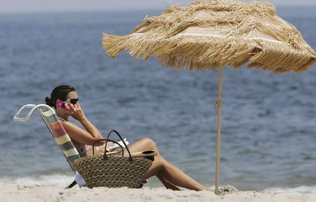 Vacancière qui téléphone sur la plage. Vacancière qui téléphone sur la plage.