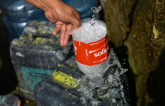 Un homme remplit un bidon avec de l'eau de la montagne Guaraira Repano à Caracas, le 21 Janvier 2016 Un homme remplit un bidon avec de l'eau de la montagne Guaraira Repano à Caracas, le 21 Janvier 2016