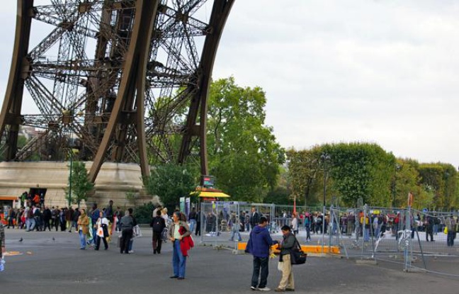 Des touristes au pied de la Tour Eiffel, à Paris, lundi 4 octobre 2010. Des touristes au pied de la Tour Eiffel, à Paris, lundi 4 octobre 2010.