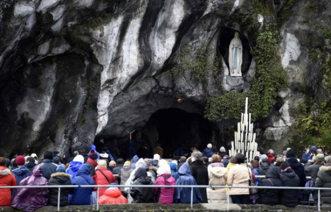 Des pèlerins devant la grotte de Massabielle à Lourdes, le 11 février 2016. Des pèlerins devant la grotte de Massabielle à Lourdes, le 11 février 2016.