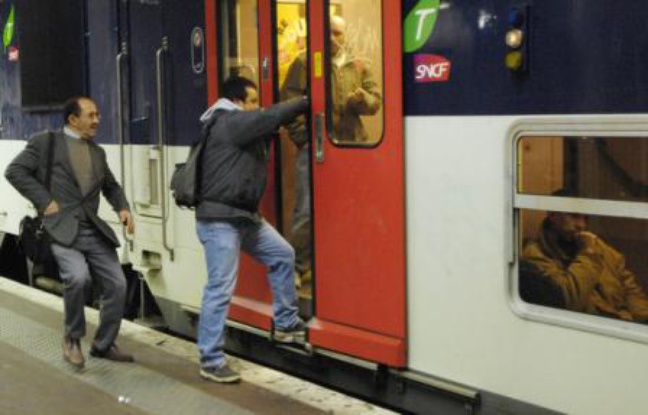 Un homme tente de monter à bord d'un RER à Paris. Un homme tente de monter à bord d'un RER à Paris.