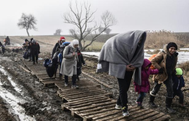 Des migrants traversent un champ boueux après avoir passé la frontière serbo-macédonienne près du village serbe de Miratovac, le 27 janvier 2016 Des migrants traversent un champ boueux après avoir passé la frontière serbo-macédonienne près du village serbe de Miratovac, le 27 janvier 2016