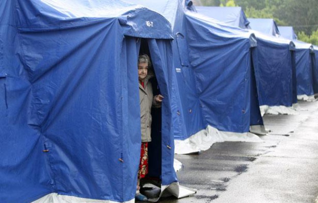 Une femme sort d'une tente dressée par les secours pour accueillir les rescapés après le tremblement de terre, à Finale Emilia, en Italie, le 21 mai 2012. Une femme sort d'une tente dressée par les secours pour accueillir les rescapés après le tremblement de terre, à Finale Emilia, en Italie, le 21 mai 2012.