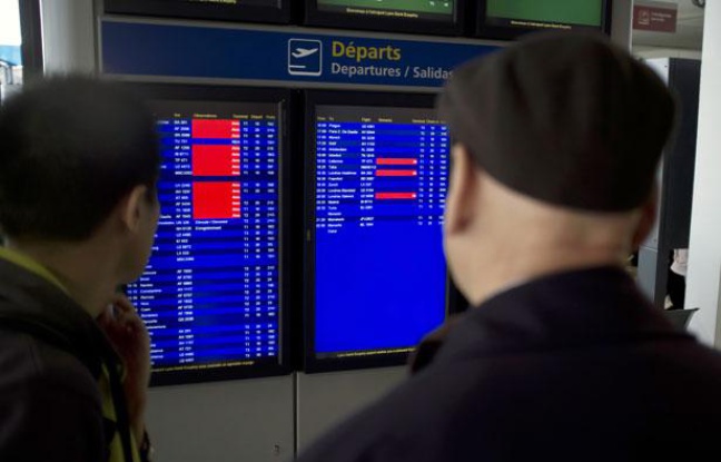 Des passagers regardent la liste des vols à l'aéroport de Lyon Saint-Exupery, le 17 décembre 2011. Des passagers regardent la liste des vols à l'aéroport de Lyon Saint-Exupery, le 17 décembre 2011.