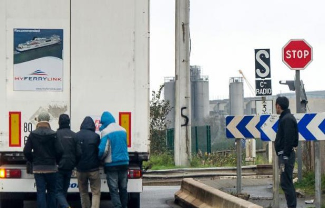 Des migrants attendent à l'arrière d'un camion non loin de la ville de Calais le 24 octobre 2014 Des migrants attendent à l'arrière d'un camion non loin de la ville de Calais le 24 octobre 2014