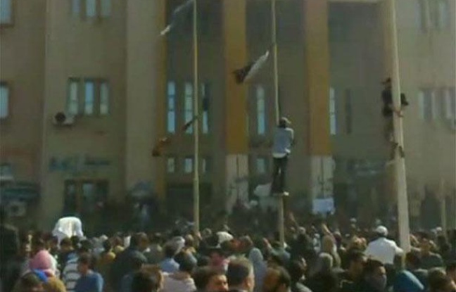Des manifestants grimpent sur des poteaux devant un bâtiment de la sécurité intérieure à Benghazi, en Libye, le 20 février 2011. Des manifestants grimpent sur des poteaux devant un bâtiment de la sécurité intérieure à Benghazi, en Libye, le 20 février 2011.