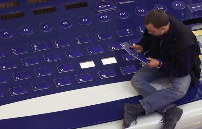 Un homme réassemble les lettres d'un clavier géant, à Hanovre (Allemagne), en février 2000. Un homme réassemble les lettres d'un clavier géant, à Hanovre (Allemagne), en février 2000.