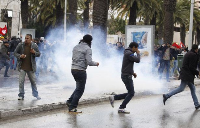 Des manifestants courent au milieu des gaz lacrymogènes à Tunis, le 6 février 2013. Des manifestants courent au milieu des gaz lacrymogènes à Tunis, le 6 février 2013.