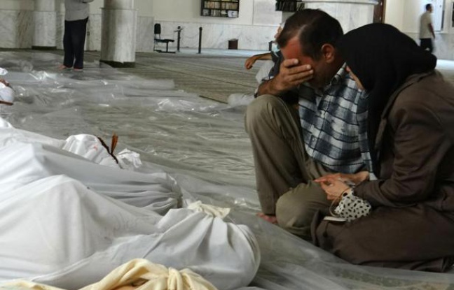 Photo fournie par le réseau d'opposition syrienne Shaam News montrant un couple pleurant face aux cadavres de proches, tués lors d'une attaque qui pourrait être d'origine chimique, le 21 août 2013 près de Damas Photo fournie par le réseau d'opposition syrienne Shaam News montrant un couple pleurant face aux cadavres de proches, tués lors d'une attaque qui pourrait être d'origine chimique, le 21 août 2013 près de Damas