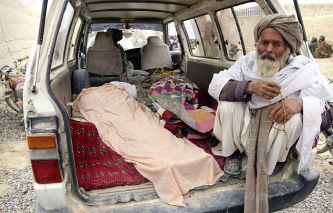 Un Afghan se tient à proximité des corps de victimes de la tuerie, le 11 mars 2012 Un Afghan se tient à proximité des corps de victimes de la tuerie, le 11 mars 2012