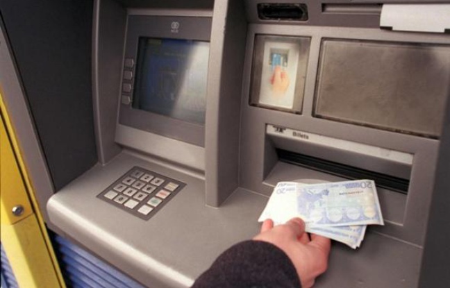 Retrait d'argent à un distributeur de billets. Retrait d'argent à un distributeur de billets.