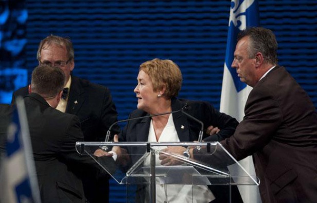 La future Première ministre Pauline Marois évacuée de la scène, où elle prononçait un discours après la victoire du Parti québécois (PQ), le 4 septembre 2012 La future Première ministre Pauline Marois évacuée de la scène, où elle prononçait un discours après la victoire du Parti québécois (PQ), le 4 septembre 2012