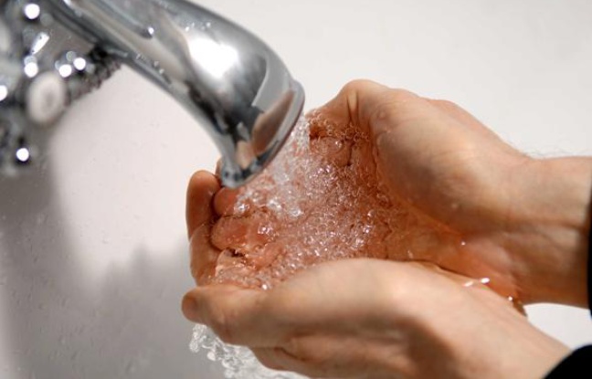 Un homme se lave les mains au robinet. Un homme se lave les mains au robinet.