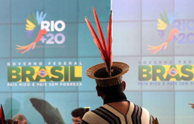 Un Indien d'Amazonie devant une affiche du sommet sur l'environnement Rio+20, à Brasilia en juin 2012. Un Indien d'Amazonie devant une affiche du sommet sur l'environnement Rio+20, à Brasilia en juin 2012.