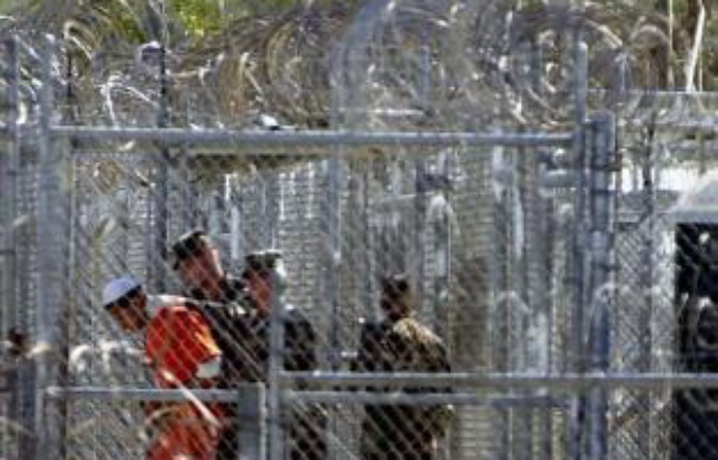 Un détenu de Guantanamo encadré par des soldats américains, en 2002 Un détenu de Guantanamo encadré par des soldats américains, en 2002