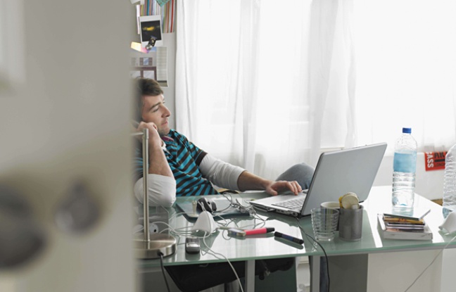 Un homme qui travaille chez lui avec un téléphone et un ordinateur. Un homme qui travaille chez lui avec un téléphone et un ordinateur.