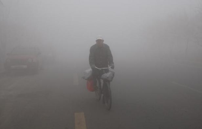 Un habitant de Harbin à vélo dans un brouillard de pollution, le 21 octobre 2013 dans le nord-est de la Chine Un habitant de Harbin à vélo dans un brouillard de pollution, le 21 octobre 2013 dans le nord-est de la Chine