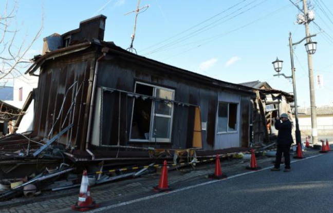 Un "touriste" photographie une des maisons abandonnées de Namie, dans la région de Fukushima, le 11 février 2016, 5 ans après l'accident nucléaire Un "touriste" photographie une des maisons abandonnées de Namie, dans la région de Fukushima, le 11 février 2016, 5 ans après l'accident nucléaire