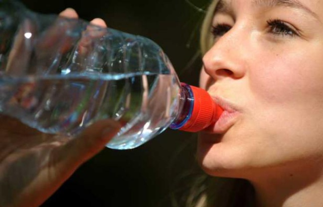 Une jeune femme en train de boire de l'eau. Une jeune femme en train de boire de l'eau.