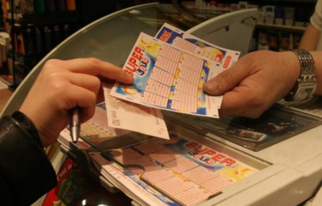 Un client achète une grille de Super Loto chez un buralistes parisien le vendredi 13 août 2010. Un client achète une grille de Super Loto chez un buralistes parisien le vendredi 13 août 2010.