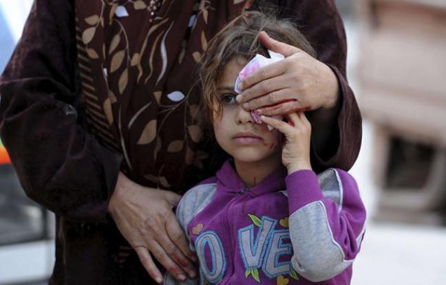 Une mère accompagne sa fille à l'hôpital après qu'un obus a frappé leur maison à Darkoush, Syrie, le 16 avril 2013. Une mère accompagne sa fille à l'hôpital après qu'un obus a frappé leur maison à Darkoush, Syrie, le 16 avril 2013.