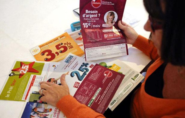 Une femme examine différentes offres de crédits à la consommation Une femme examine différentes offres de crédits à la consommation