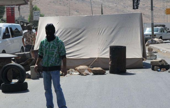 Un homme masqué appartenant à un groupe sunnite, bloque une route à la frontière libano-syrienne, à Masnaa, dans l'Est du Liban, le jeudi 16 août 2012 Un homme masqué appartenant à un groupe sunnite, bloque une route à la frontière libano-syrienne, à Masnaa, dans l'Est du Liban, le jeudi 16 août 2012
