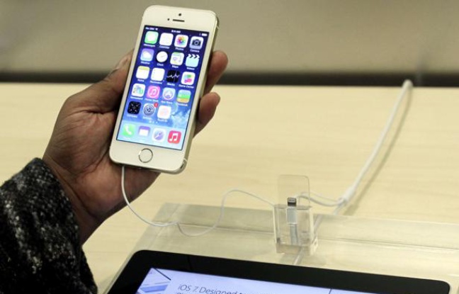 Une homme tient un iPhone 5S dans l'Apple store de New-York, le 20 septembre 2013. Une homme tient un iPhone 5S dans l'Apple store de New-York, le 20 septembre 2013.