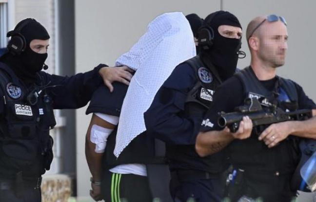 Yassin Salhi escorté par des polciers alors qu'il vient de récupérer son passeport dans son appartement de Saint-Priest avant d'être transféré à Paris, le 28 juin 2015 Yassin Salhi escorté par des polciers alors qu'il vient de récupérer son passeport dans son appartement de Saint-Priest avant d'être transféré à Paris, le 28 juin 2015