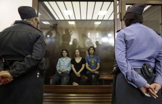 Les trois membres de Pussy Riot sont assises derrière une glasse de verre lors de leur procès, le 17 août 2012 à Moscou. Les trois membres de Pussy Riot sont assises derrière une glasse de verre lors de leur procès, le 17 août 2012 à Moscou.