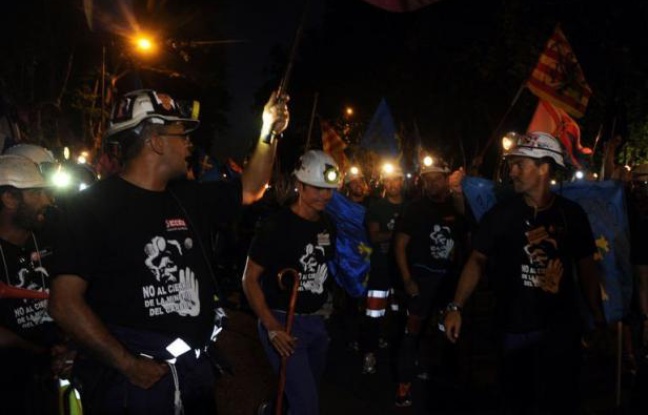 A la lumière de leurs lampes frontales, casque sur la tête, des centaines de mineurs espagnols en grève, venus à pied du nord du pays, ont parcouru mardi les rues de Madrid lors d'une marche nocturne pour protester contre la réduction des aides publiques. A la lumière de leurs lampes frontales, casque sur la tête, des centaines de mineurs espagnols en grève, venus à pied du nord du pays, ont parcouru mardi les rues de Madrid lors d'une marche nocturne pour protester contre la réduction des aides publiques.