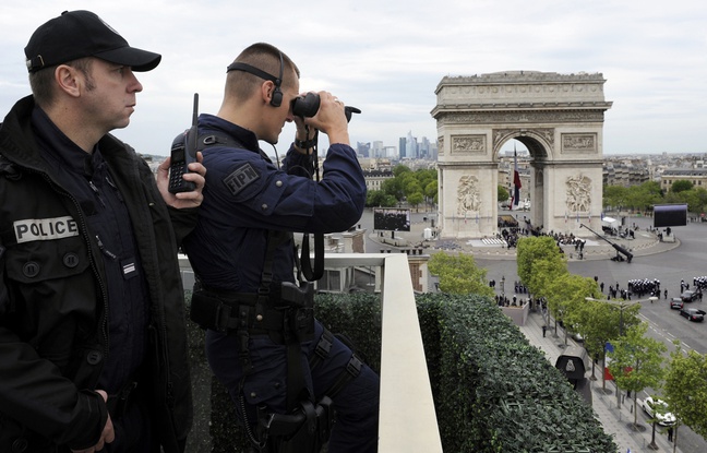 Des policiers observent les passants autour de l'Arc de Triomphe à Paris. Des policiers observent les passants autour de l'Arc de Triomphe à Paris.