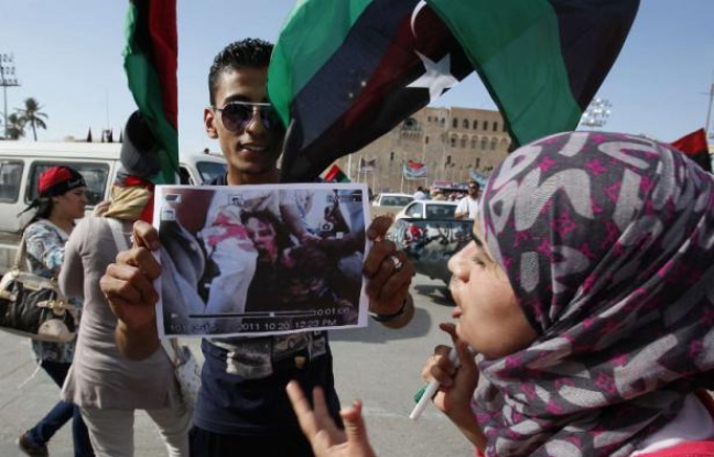 Un Libyen tient une photo de la dépouille de Kadhafi, le 20 octobre 2011. Un Libyen tient une photo de la dépouille de Kadhafi, le 20 octobre 2011.