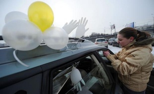 Des centaines de Moscovites ont roulé dimanche dans leurs voitures ornées de ballons et de rubans blancs autour du Kremlin pour protester contre le retour attendu du Premier ministre Vladimir Poutine au Kremlin après la présidentielle du 4 mars.