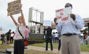Des Américains dénoncent la mort d'un jeune Noir tué par un policier blanc ayant tiré à au moins six reprises, à Ferguson le 17 août 2014