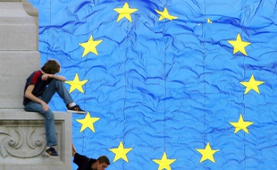 Des enfants jouent devant un drapeau européen, en mai 2004, à Bruxelles.