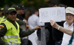 Un homme brandit une pancarte où est inscrit "La prison pour les FARC" lors d'une manifestation organisée par les citoyens et les familles de victimes des FARC, le 25 avril 2015, à Cali en Colombie