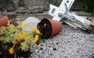 Crucifix et pot de fleurs renversés sur une tombe dégradée le 15 avril 2015 dans le cimetière à Castres