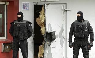 Des enquêteurs devant une porte de la prison de Sequedin détruite à l'explosif lors de l'évasion de Rédoine Faïd, le 13 avril 2013.