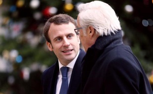 Le ministre de l'Economie Emmanuel Macron (G) discute avec le ministre du Travail Francois Rebsamen à leur arrivée à l'Elysée le 5 janvier 2015 pour le conseil des ministres