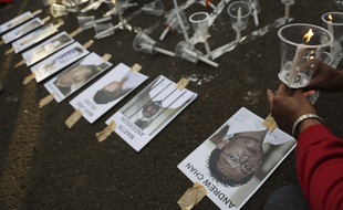 Un activiste indonésien dépose le portrait des huit étrangers condamnés à mort, à Jakarta, le 28 avril 2015.