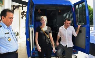 Les journalistes français d'Arte Thomas Dandois (d) et Valentine Bourrat (c) à leur arrivée le 10 octobre 2014 en fourgon pénitentiaire au parquet de Jayapura, dans l'est de l'Indonésie