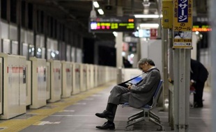 Un cadre assoupi sur un banc dans le métro de Tokyo le 22 mai 2015